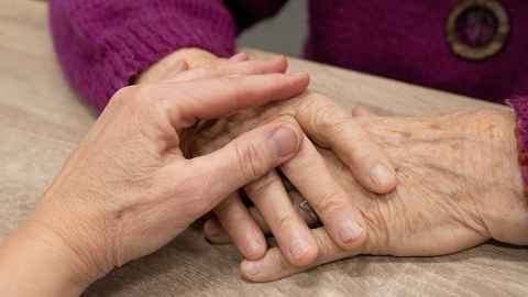 Close up shot of two hands holding each other.