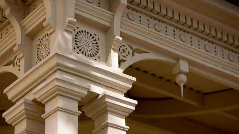 Building detail of top of white plinth and arch.